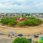 Rond-point étoile rouge avec statue et verdure.