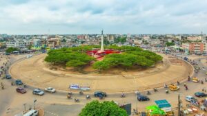 Rond-point étoile rouge avec statue et verdure.