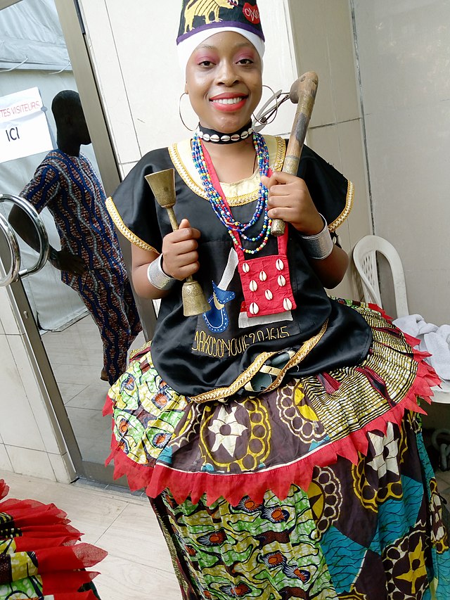 Danseuse traditionnelle exécutant le rythme Zinli à Abomey, parée d'accessoires royaux lors d'une cérémonie culturelle du Danxomè