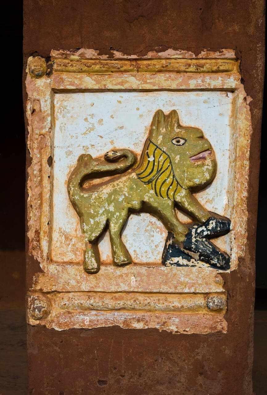 Gros plan sur un bas-relief historique du Roi Glélé au Palais Royal d'Abomey, symbole de la puissance du Royaume du Dahomey