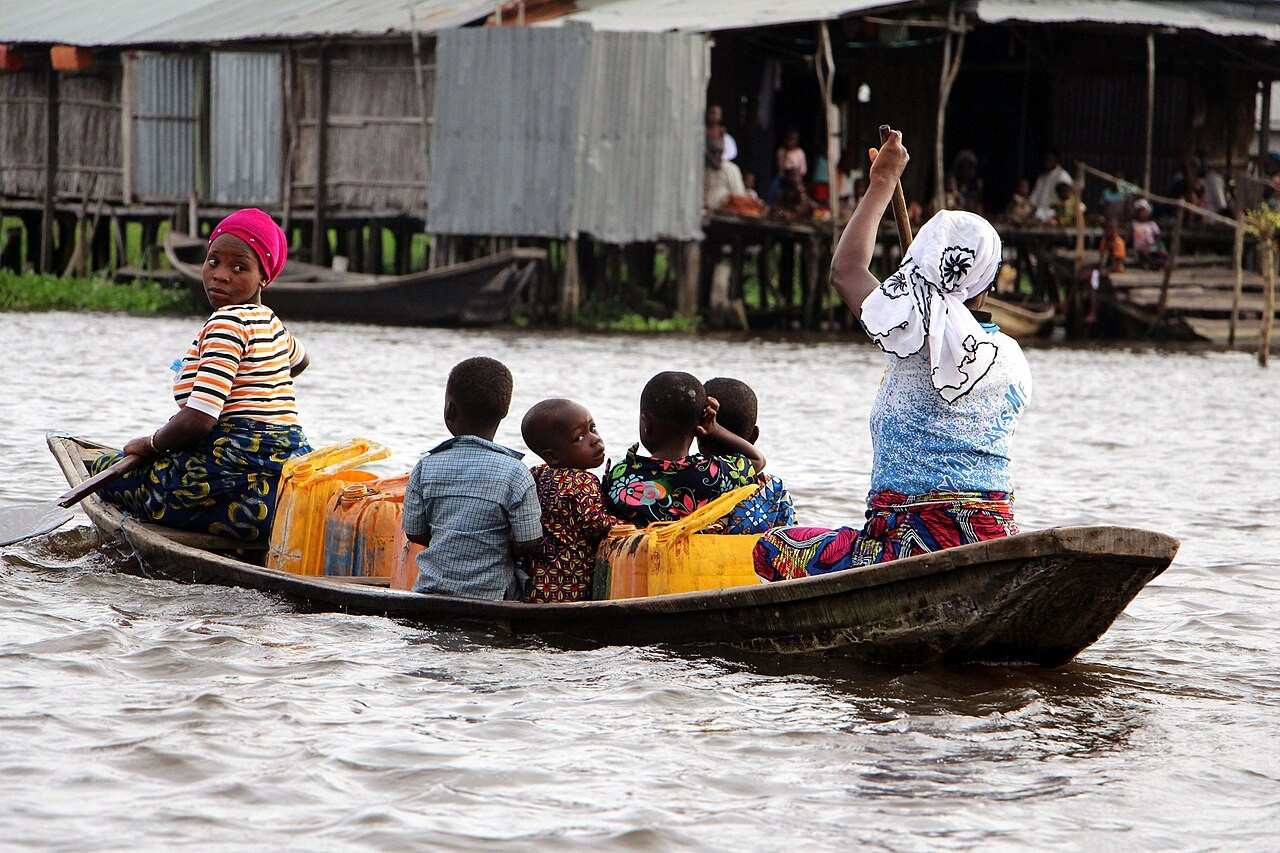 Vie quotidienne sur le lac Nokoué à Ganvié, transport en pirogue et logistique de l'eau potable