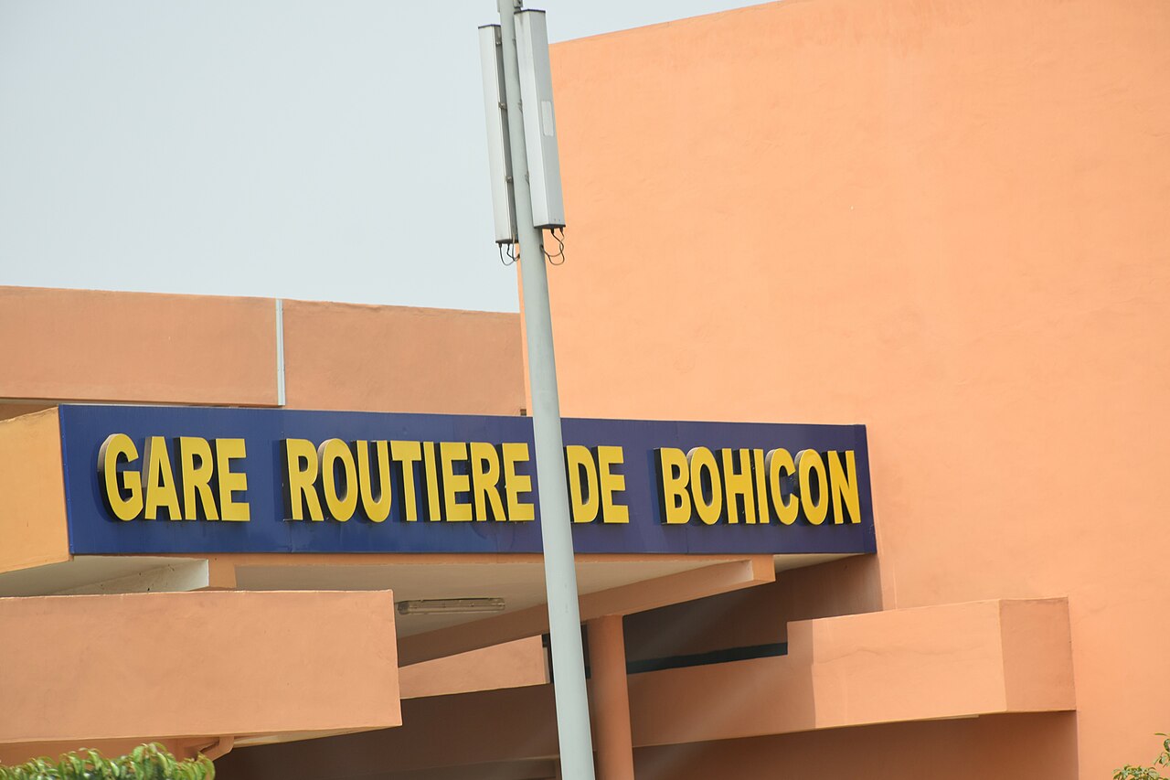 Gare routière animée de Bohicon avec bus et taxis, carrefour de transport vers Dassa et le Nord Bénin