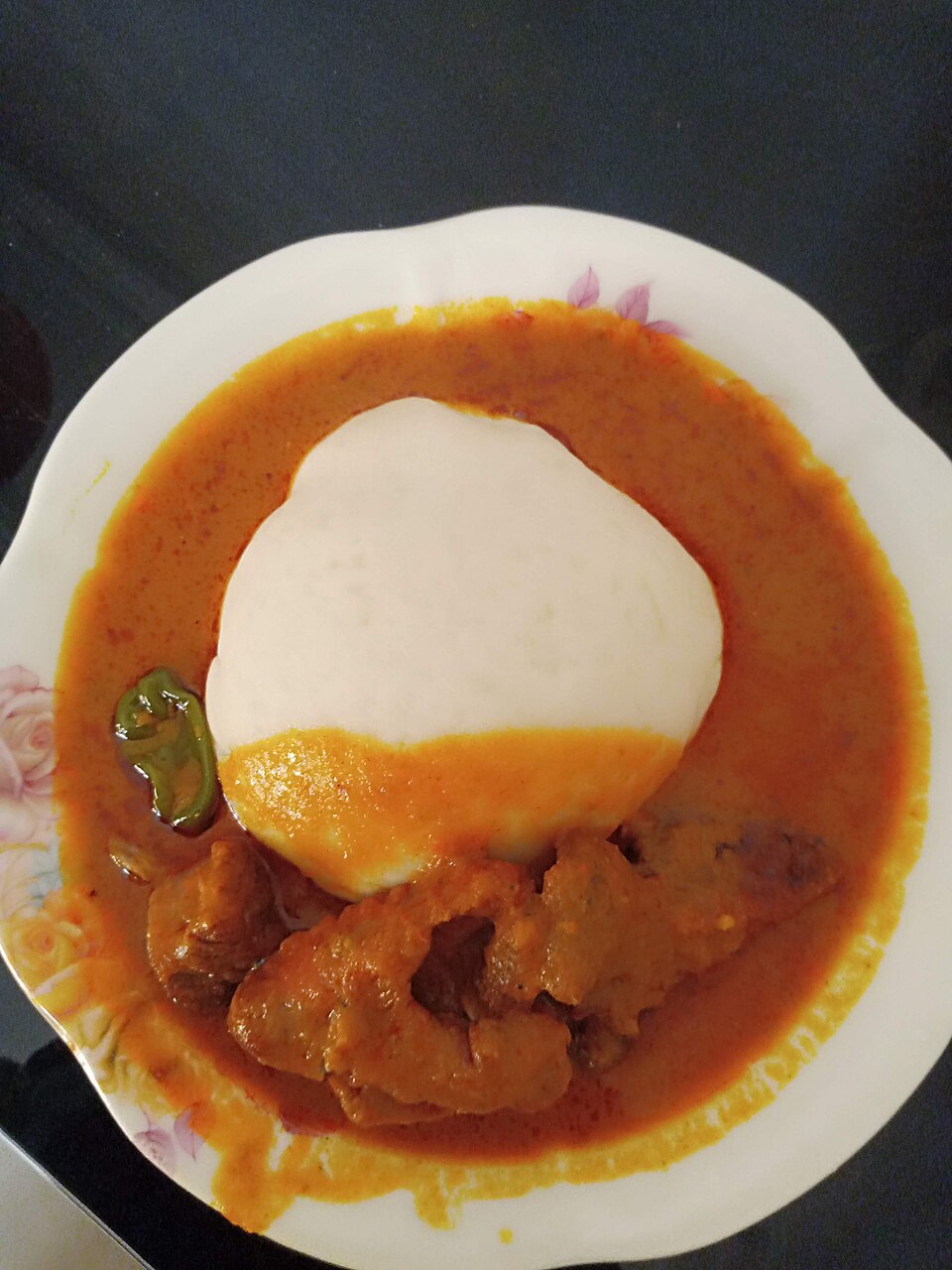 Préparation traditionnelle de l'igname pilée dans un maquis local à Parakou