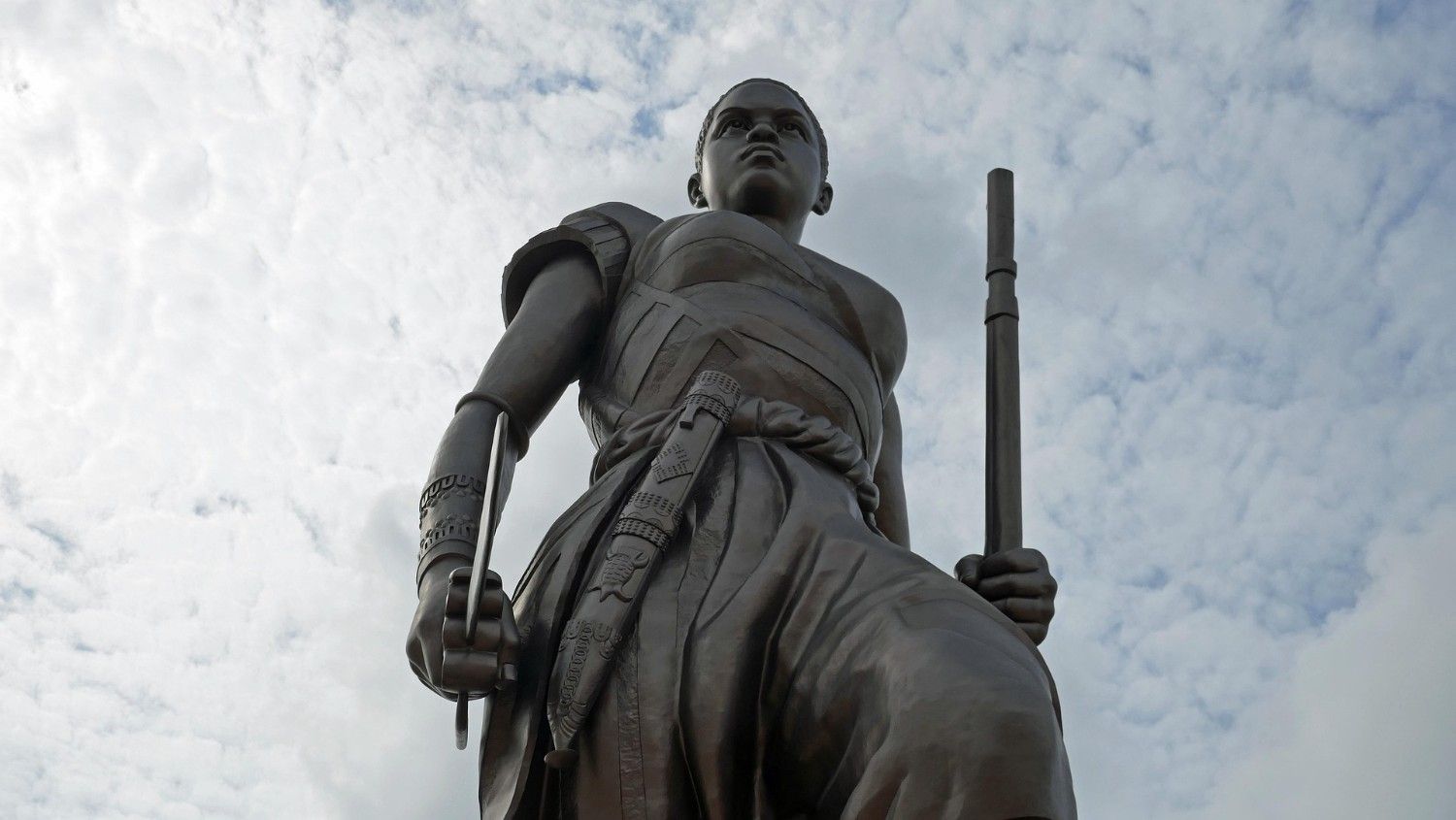 Statue de l'Amazone au Bénin sous un ciel bleu, symbole d'intégration et de business
