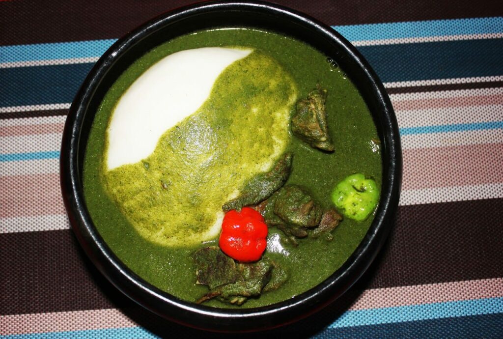 Que manger pour découvrir la cuisine béninoise ? 3 Assiette traditionnelle de cuisine béninoise, notamment un plat d'igname pilée avec sauce tchayo servie à Cotonou