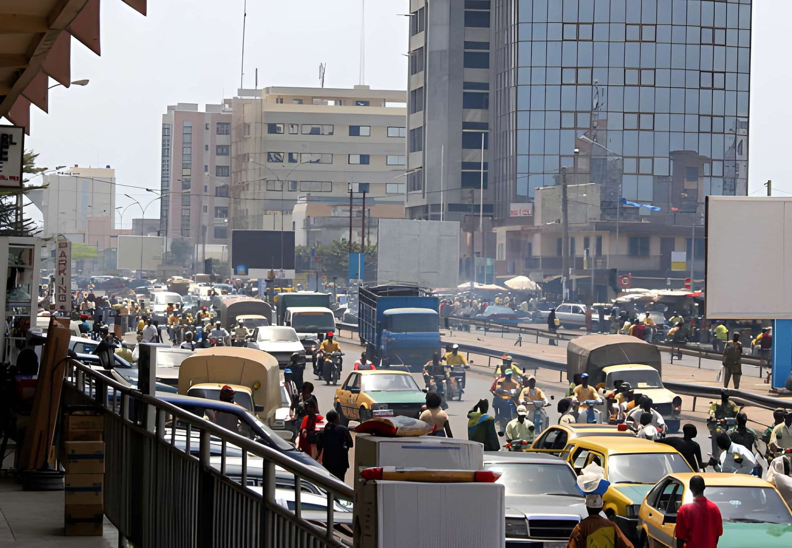 Rue animée de Cotonou avec zémidjans et vendeurs de rue, Bénin