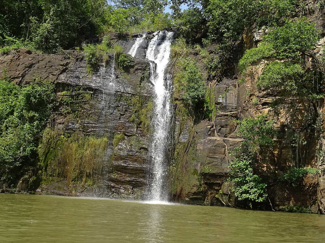 Bassin naturel des chutes de Tanongou entouré de végétation dans l'Atacora au Bénin