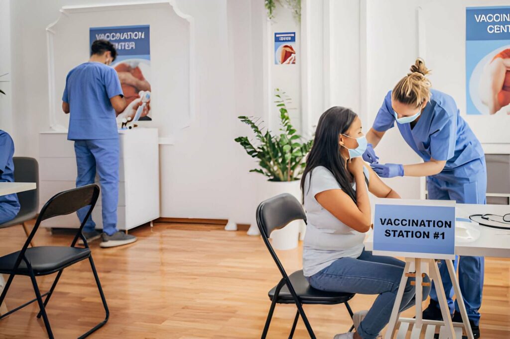 Vaccins et paludisme : comment préparer sa santé au Bénin ? 4 Médecin réalise une injection dans un centre de vaccination internationale avant un départ