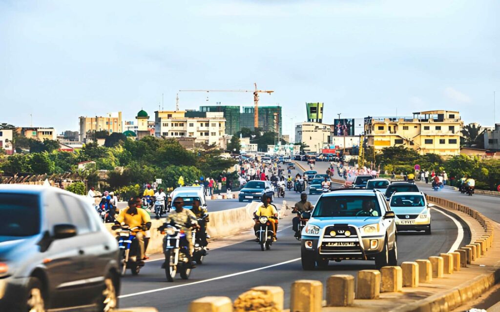 Voiture roulant sur une route goudronnée du Bénin en pleine journée, symbole de conduire au Bénin en toute sécurité