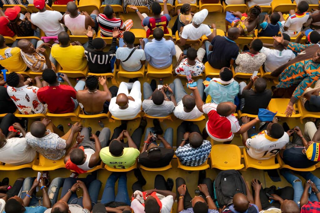 Supporters rassemblés lors d'événements sportifs au Bénin dans un stade animé de Cotonou
