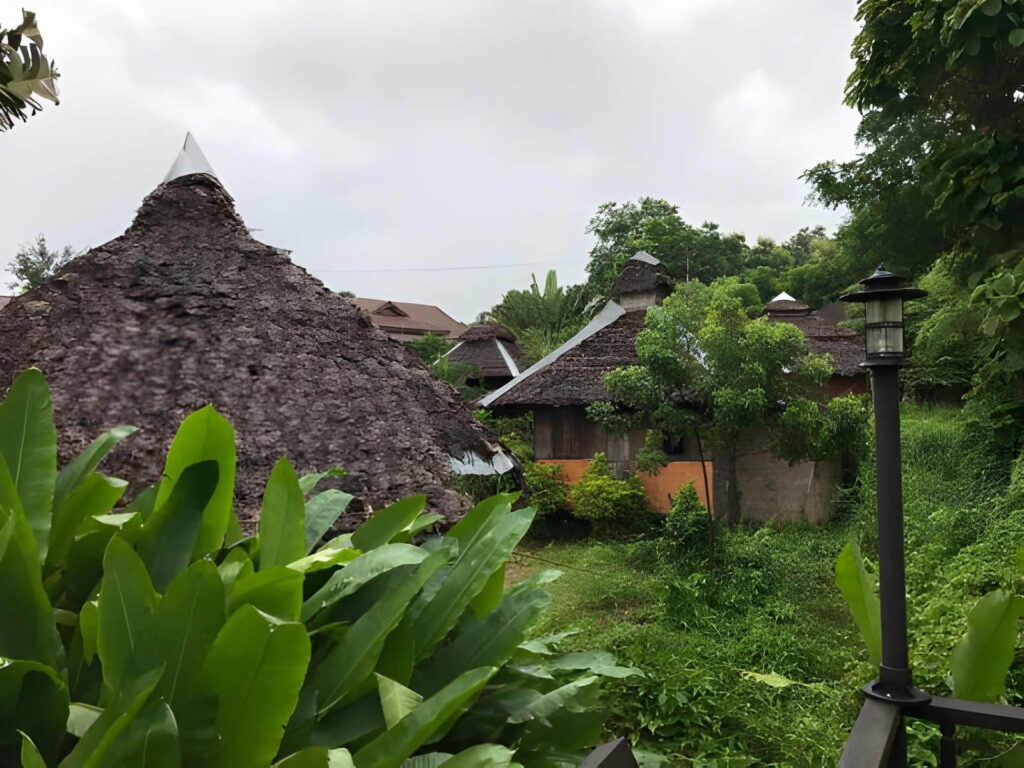 Cour d'un hôtel à Natitingou avec toit traditionnel, ambiance calme typique du nord du Bénin