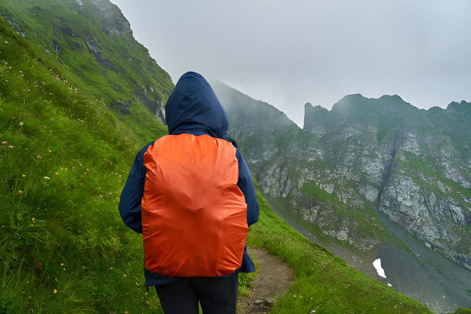 Housse imperméable recouvrant un sac à dos sous la pluie