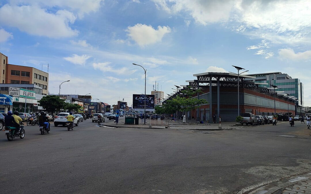 Scène de rue animée à Cotonou illustrant la diversité de la population du Bénin