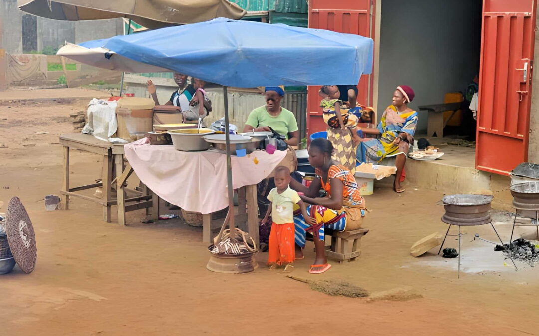 Maquis de rue au Bénin avec femmes, marmites et foyer de cuisson en plein air
