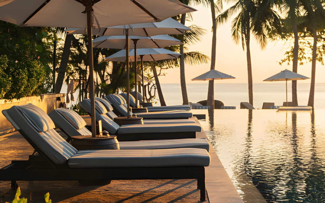 Piscine d'hôtel à débordement face à la mer, avec transats, parasols et palmiers, illustrant un hôtel avec piscine à Cotonou