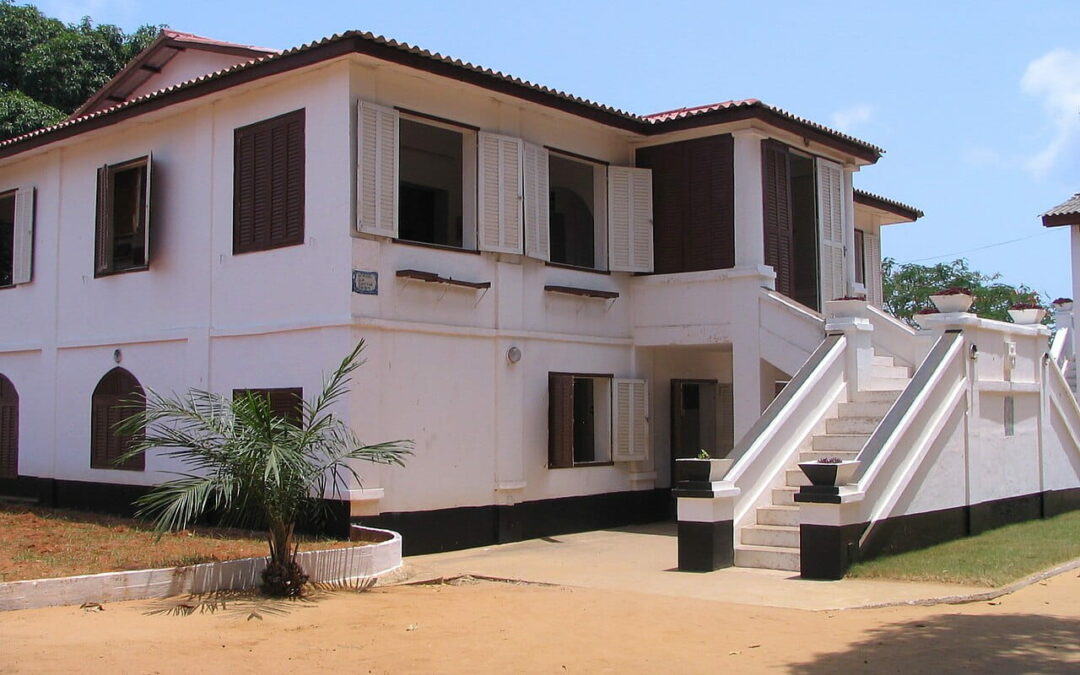 Bâtiment blanc à étage, volets bruns et escalier extérieur, dans le fort portugais qui abritait le musée de Ouidah, au Bénin